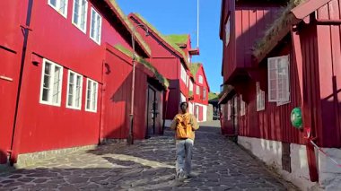 Torshavn 'un pitoresk caddelerinde dolaşın, çimen çatılarıyla süslenmiş canlı kırmızı ahşap evler büyüleyici bir atmosfer yaratır. Sahne İskandinav cazibesinin özüyle dolu..