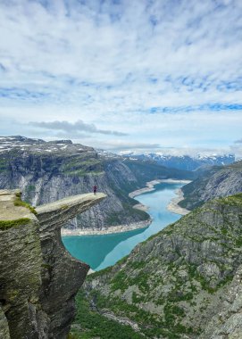 Norveç 'teki sakin bir manzara, derin fiyortlara ve yüksek uçurumlara bakan çarpıcı bir bakış açısına sahiptir. Norveç 'te Trolltunga yürüyüşü