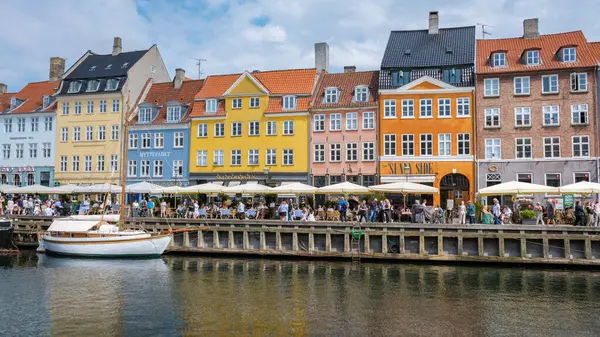 Nyhavn, Kopenhag, Danimarka, 12 Temmuz 204: Konforlu kafeler, ziyaretçileri mimarinin canlı renklerinin tadını çıkarmaya davet ediyor..