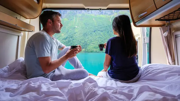 Bir çift rahat bir karavanda dinleniyor, kahveyi yudumlarken nefes kesici Norveç manzarası seyrediyor. Sakin sular ve tepeler mükemmel bir sabah ortamı yaratır..