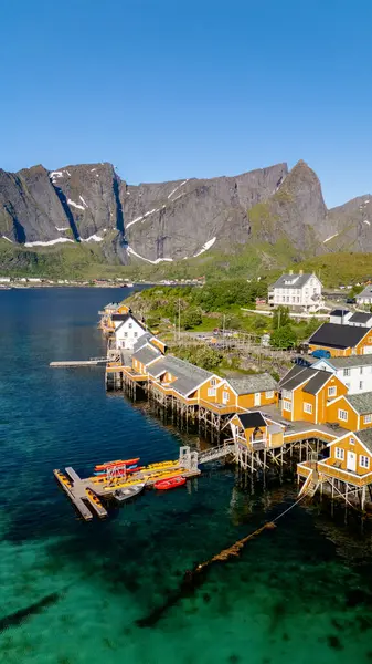 Kaleler üzerindeki renkli ahşap kulübeler görkemli dağlarla çevrili Norveç fiyortlarının sakin suları boyunca uzanır. Mükemmel bir yaz günü Lofoten Adaları 'nın güzelliğini vurgular..