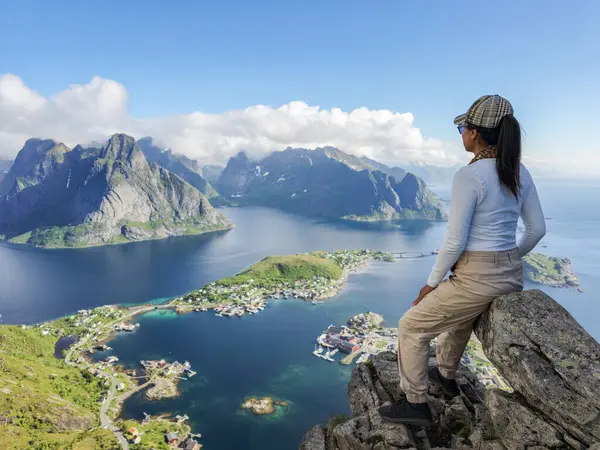 Bir gezgin Norveç 'in Lofoten Adaları' ndaki bir dağ zirvesinden çarpıcı manzaralara hayran..