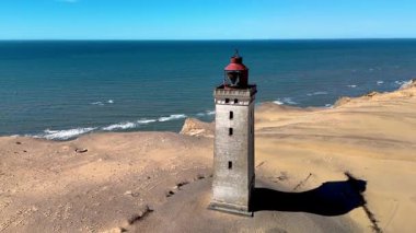 Danimarka 'nın Jutland kentindeki güzel Rubjerg Knude Fyr Feneri' ni keşfedin. Orada tarihi bir deniz feneri yumuşak kum tepelerine ve huzur dolu bir denize bakar. Dinlenme ve macera için mükemmeldir..