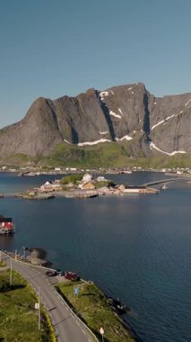 Sakin suların yükselen dağları yansıttığı gibi Lofoten Norveç kıyı şeridinin nefes kesici güzelliğini deneyimleyin. Yakınlardaki yerleşim yerleri, altın saat boyunca bu barışçıl doğal geri çekilmeye cazibe katıyor..