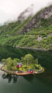 Norveç 'in çarpıcı manzarasının ortasına yerleşmiş büyüleyici kırmızı kulübeler sakin suların tadını çıkarıyor. Yeşillik ve görkemli dağlar Lovrafjorden, Norveç manzarasını güzelleştirir.