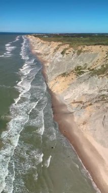 Danimarka 'nın Jutland kentindeki Rubjerg Knude Fyr Deniz feneri sahilinin nefes kesen sahil şeridini keşfedin. Dalgaların yükselen kayalıkların altındaki kumlu sahile hafifçe çarptığı yerde güzellikler sergilenmektedir..