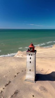 Hava perspektifleri, Jutland sahili boyunca uzanan Rubjerg Knude Fyr Deniz Feneri 'ndeki eşsiz deniz fenerini gösteriyor. Kumlu kıyıların arasına yerleşmiş bu yer, geniş okyanus manzaralı huzurlu bir kaçış sunuyor..