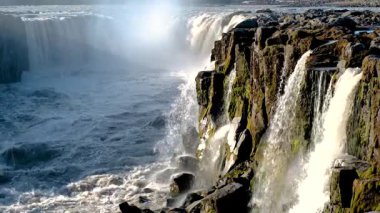 İzlanda 'daki Dettifoss Şelalesi' nin nefes kesici güzelliğini tecrübe edin. Güçlü su, sakin bir manzara ve büyüleyici bir ışıkla çevrili dramatik uçurumların üzerine düşer. Doğa aşıkları için mükemmel..