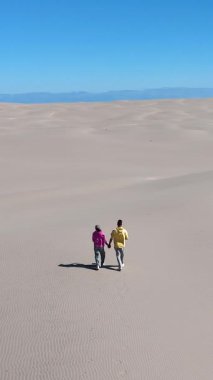 Çift, Rabjerg Mile Jutland 'ın engin kumullarında el ele yürür. Açık mavi gökyüzü, Danimarka 'nın huzurlu manzarasında romantik maceraları için mükemmel bir zemin oluşturuyor..
