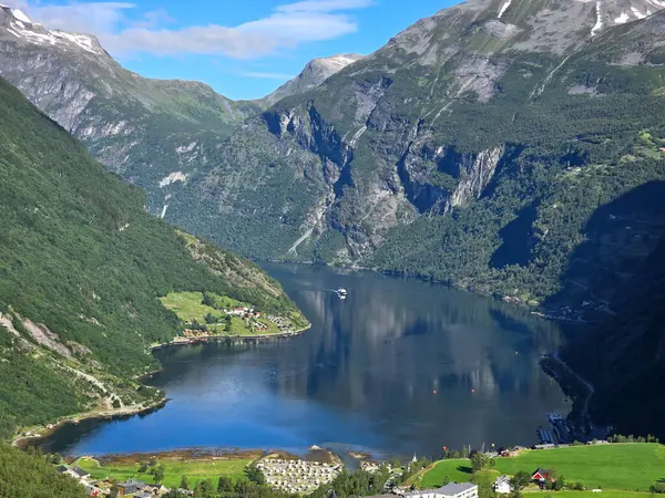 Yüksek dağlar ve yemyeşil yeşilliklerle çevrili bir Norveç fiyordunun nefes kesici manzarası. Norveç 'in Geiranger' si,