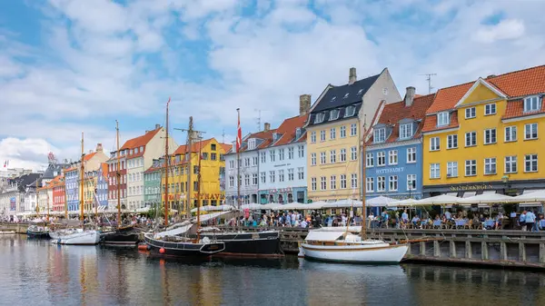 Nyhavn, Kopenhag, Danimarka, 12 Temmuz 204: Canlı binalar Danimarka 'nın pitoresk bir liman kasabasında, yerel kafe ve dükkanlardan keyif alan turistlerle dolu bir liman kenti.. 