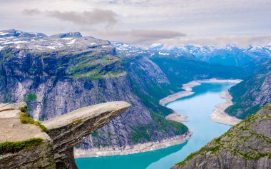 Kayalıklardan nefes kesen manzara, titreyen turkuaz suları ve dramatik dağ oluşumlarını gözler önüne seriyor. Trolltunga, Norveç