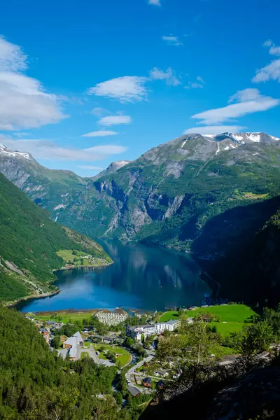 Norveç 'in nefes kesici fiyortları berrak mavi gökyüzü altında nefes kesici dağ manzaraları sergiliyor. yemyeşil tepeler sakin sularla buluşur, doğa aşıkları için mükemmel bir dinlenme yeri oluşturur..