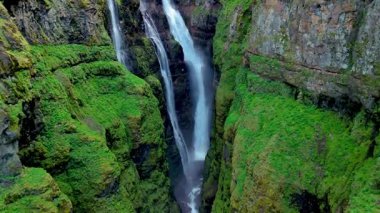Güçlü şelaleler zarif bir şekilde yeşil kayalıklardan aşağı akarken İzlanda 'nın nefes kesici güzelliğini keşfedin. İzlanda 'daki Glymur şelalesi kanyonu