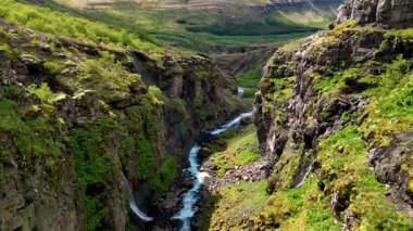 İzlanda 'nın nefes kesici güzelliği dingin bir nehir gibi yemyeşil bir kanyonda esiyor. Yükselen kayalıklar ve canlı bitki örtüsü büyüleyici bir atmosfer yaratıyor, Glymur şelale kanyonu İzlanda
