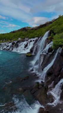 Enfes Barnafoss ve Hraunfossar şelalelerini keşfedin kristal berrak su engebeli kayaların üzerinde çağlarken.