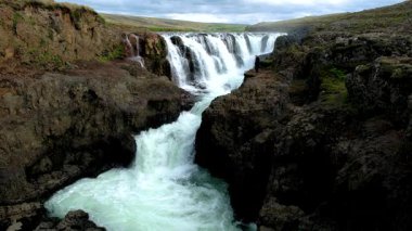 İzlanda 'daki Godafoss Şelalesi' nin büyüleyici akışına tanık olun. Kayalık arazide çağlayan sular eşsiz oluşumlar ve sakin bir çevre yaratıyor.. 