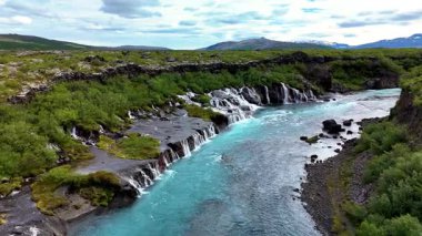Barnafoss ve Hraunfossar 'ın şelalelerini görün, İzlanda' da yemyeşil bir araziye karşı kurulmuştur..