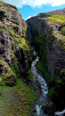 İzlanda 'da nefes kesici bir Glymur şelalesi kanyonu keşfet. Engebeli kayalıkların canlı yeşilliklerle buluştuğu yer. Huzurlu bir nehir, berrak bir gökyüzü altında büyüleyici bir doğal manzara yaratır..