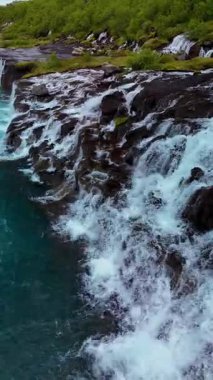 İzlanda 'daki volkanik kayaların üzerinden çağlayan su gibi büyüleyici Barnafoss ve Hraunfossar şelalelerini keşfedin. Doğanın gücü ve güzelliği tam gösterimde..