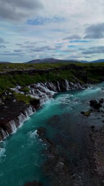 Nefes kesici Barnafoss ve Hraunfossar şelalelerini keşfedin. Kristal berraklığında turkuaz sular, bereketli yeşillik ve dramatik manzaralarla çevrili engebeli lav kayaları üzerinde zarifçe akıyor..