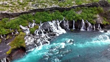 İzlanda 'daki Barnafoss ve Hraunfossar' daki yosun kaplı kayaların arasından akan kristal berrak suların büyüleyici akışını tecrübe edin. Doğa bu nefes kesici İzlanda manzarasında parlıyor..