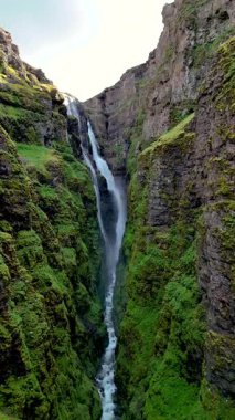 Su, İzlanda 'daki yosun kaplı uçurumların içine yerleştirilmiş çarpıcı bir şelaleden akarak saf güzelliği gözler önüne seriyor. İzlanda 'daki Glymur şelalesi kanyonu