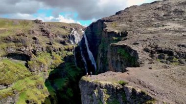 Canlı yeşil tepeler ve dramatik kaya oluşumlarıyla çevrili engebeli uçurumların üzerinden zarif bir şekilde nefes kesici bir şelale akar. Glymur şelale kanyonu İzlanda