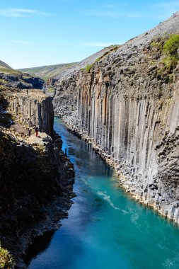 İzlanda 'daki Studlagil Kanyonu' nun berrak turkuaz sularını çevreleyen bazalt sütunların şaşırtıcı uçurumları.