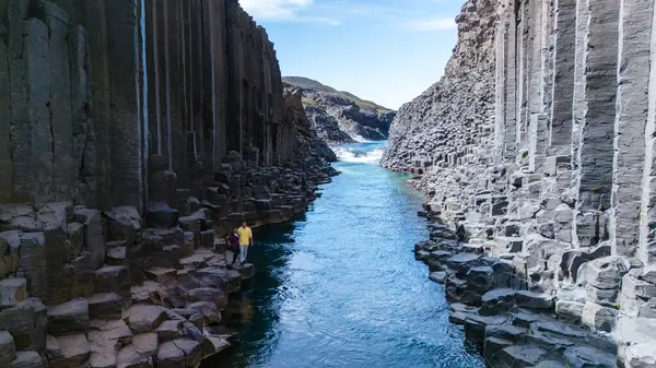 İzlanda 'daki Studlagil Kanyonu' nun etkileyici kaya oluşumları arasında sakin suların aktığı şaşırtıcı bazalt sütunlarına hayret edin. Canlı renkler sakin ama görkemli bir atmosfer yaratıyor..