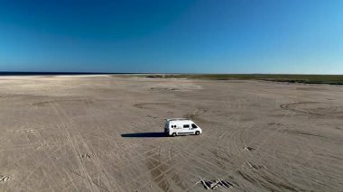 Danimarka 'daki Romo Lakolk plajının huzurlu güzelliğini yaşayın. Açık mavi gökyüzünün altında geniş bir kumlu karavan, macera ve rahatlamaya davetiye çıkarıyor..