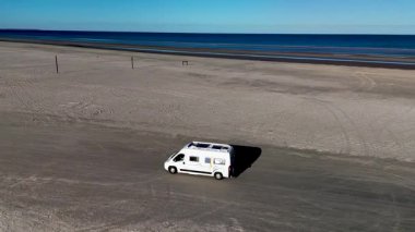 Romo Danimarka 'nın Lakolk plajındaki dinginliğini bir karavanın uçsuz bucaksız kumlu arazide süzülüşünü yaşayın. Huzurlu kıyı şeridi ve uçsuz bucaksız ufuk mükemmel bir kaçış sağlar..