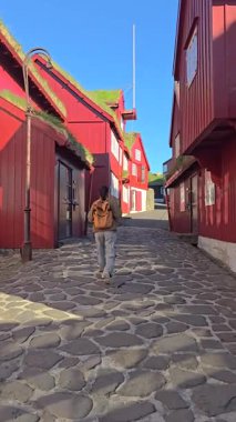 Torshavn 'un renkli caddelerinde dolaşın, geleneksel ahşap evlerin parlak gölgelerle boyandığı kaldırım taşları yollarında. Bu canlı atmosfer ada yaşamının özünü yakalar..