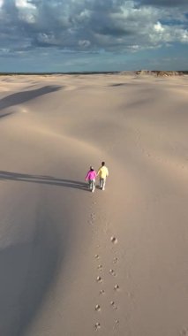 Danimarka, Rabjerg Mile Jutland 'ın yumuşak kumlu kumullarında el ele dolaşarak arkalarında ayak izleri bırakırlar. Manzara, güneşin sıcacık parıltısıyla güzelce aydınlatılır.