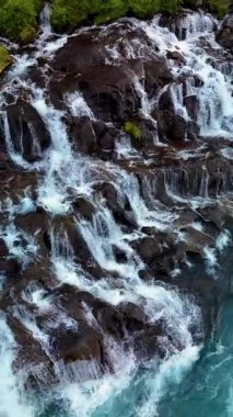 Su, Barnafoss ve Hraunfossar 'daki kayaların üzerinde zarifçe akarak büyüleyici bir görüntü oluşturur. Bu hareketli ortam İzlanda doğasının sakin atmosferini güçlendiriyor..