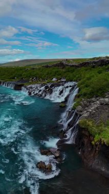 İzlanda 'da iki büyüleyici şelale olan Barnafoss ve Hraunfossar' ın güzelliğini görün. Turkuaz sular canlı yeşil araziler üzerinde çağlayarak doğaya huzurlu bir kaçış yaratır..