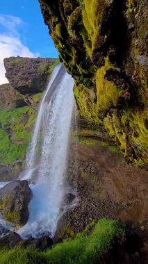 Zarif bir şekilde akan Seljalandsfoss şelalesi, yeşil arazide nefes kesici bir sis oluşturarak yüksekten yuvarlanır. Bu ikonik İzlanda sitesi doğanın huzurunu davet ediyor..