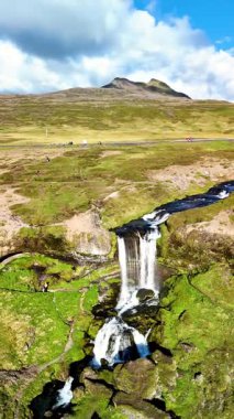 İzlanda 'nın büyüleyici manzarasını keşfedin. Selvallafoss şelalesi canlı yeşil yosunlu arazide çağlayarak akıyor..