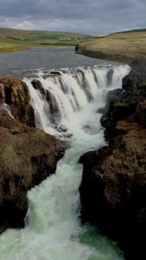 İzlanda 'daki Kolugljufur Kanyonu' nun nefes kesen güzelliğini tecrübe edin. Güçlü şelalelerin engebeli kaya oluşumları ve yosunlu manzaralarla çevrili canlı mavi sulara düştüğü yer..