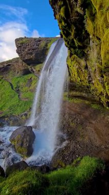 Selvallafoss şelalesinin güçlü suları engebeli uçurumlarla çevrili yemyeşil bir vadiye dökülüyor. Güneş ışığı bu hayret verici doğa harikasını aydınlatır, dingin bir atmosfer yaratır..