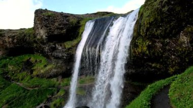 Selvallafoss şelalesinin İzlanda 'daki engebeli kayaların üzerinden yuvarlanışının nefes kesici güzelliğine tanık olun. Çevreyi çevreleyen canlı yeşil yosunlar adanın doğal ihtişamını yansıtıyor..