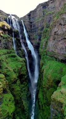 İzlanda 'daki Glymur şelalesi kanyonundaki yüksek yeşil uçurumlarla çevrili sakin bir vadiye nefes kesici bir şelale düşer. Parlak manzara doğayı, saf güzelliği ve huzuru yakalar.