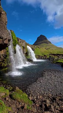 Görkemli Kirkjufell dağına tanık olun. Etrafı yemyeşil yamaçlar ve kristal berrak şelalelerle çevrili. İzlanda 'daki bu nefes kesici yer eşsiz bir güzellik ve sükunet sunuyor..
