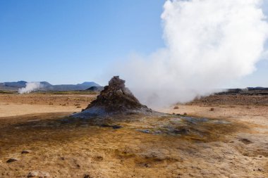 İzlanda 'nın dağlık bölgelerindeki jeotermal bir kaplıcadan yükselen buhar, dünya dışı bir atmosfer yaratıyor. Kurak arazi, parlak güneş ışığı altında eşsiz jeolojik oluşumlar sergiliyor..