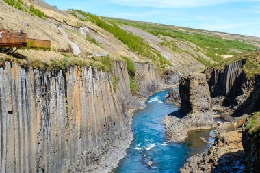 Studlagil Kanyonu 'nun eşsiz güzelliğini keşfedin, kristal berrak suların bazalt sütunlar arasında aktığı. Bu İzlanda harikası maceraperestleri ve doğa aşıklarını büyülüyor..