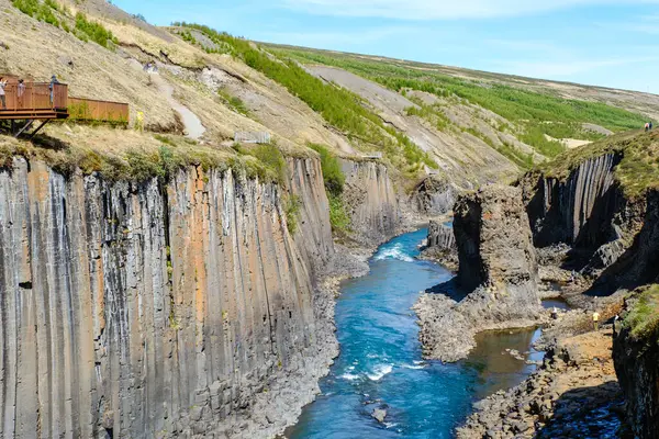 Studlagil Kanyonu 'nun eşsiz güzelliğini keşfedin, kristal berrak suların bazalt sütunlar arasında aktığı. Bu İzlanda harikası maceraperestleri ve doğa aşıklarını büyülüyor..