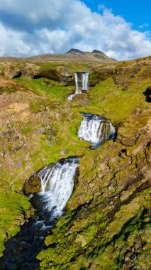 Sersemletici Selvallafoss şelalesi İzlanda 'nın canlı yeşil manzarasıyla çevrili kayalık uçurumlardan zarifçe aşağı akıyor.