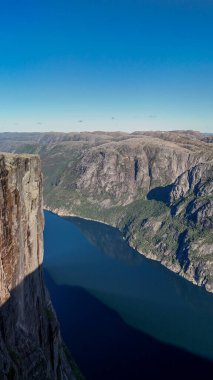 Görkemli uçurumlar Norveç fiyortlarında sakin suların üzerinde keskin bir şekilde yükselir ve Norveç 'in nefes kesici manzaralarının özünü yakalar. Kjeragbolten Lysefjord, Norveç