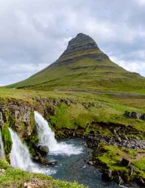 İzlanda 'nın sakin kırsalında çağlayan şelaleleri ile Kirkjufell dağının nefes kesici manzarası