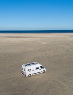 Romo Danimarka 'da geniş bir kumlu plajda açık gökyüzü ve sakin okyanus dalgalarıyla çevrili bir karavan. Rahatlama ve doğa arayan gezginler için idealdir..